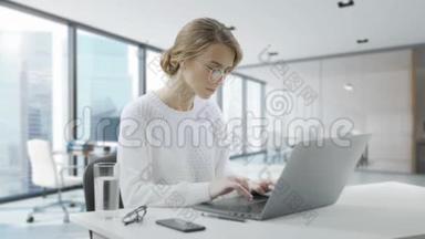 女人<strong>坐在</strong>办公桌<strong>前</strong>用笔记本<strong>电脑</strong>。 年轻的欧洲女商人正<strong>坐在</strong>办公室里工作
